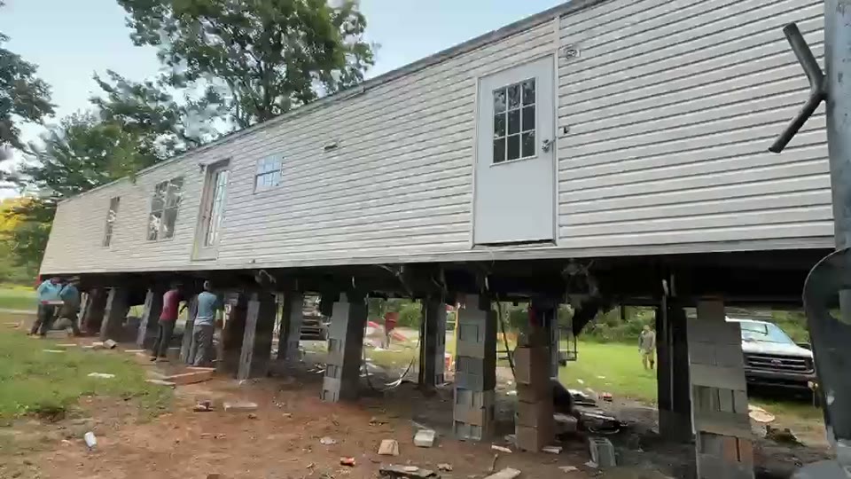 A double-wide raised on cribbing so it can be leveled. Built by Asheville Modular and Mobile Home Services.